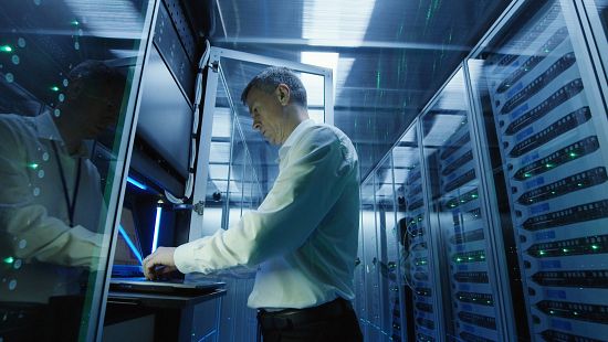 Businessman inside a server room at a data center.